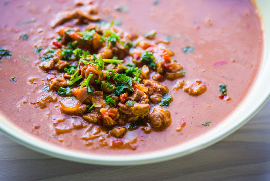 Rindfleischeintopf oder Gulaschsuppe mit Fleischst&uuml;cken in roter Tomaten sauce