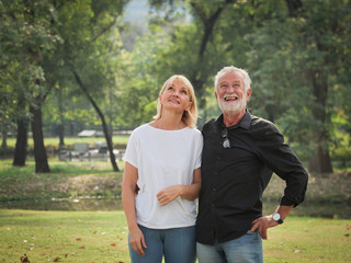 Obraz premium Two happy seniors retirement Man and woman are walking and talking in park