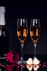 Two glasses of champagne, rose and heart shape chocolates