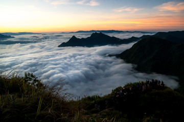 Tourists are looking at sunrise and sea of fog view on phu chi fa mountain area and national forest park in chiang rai, Thailand.