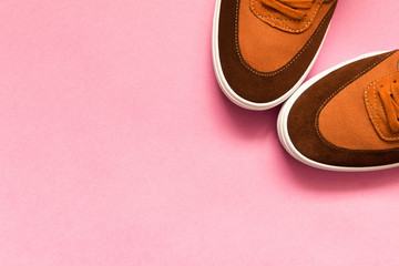 A pair of new sneakers on a pink background. Empty text space.