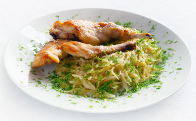 stewed white cabbage decorated with dill and fried rabbit legs  