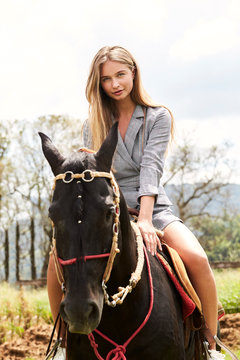 Gorgeous woman riding horse, portrait
