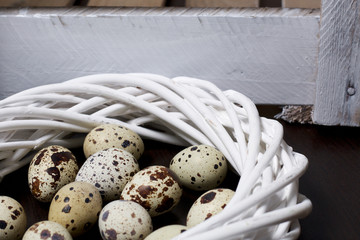 Quail eggs. Lie in a wreath of vines. Next to the wooden box.
