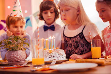 Serious blonde girl making her cheeks big