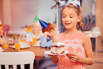 Fototapeta premium Portrait of charming girl that blowing candle