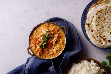 Indian cuisine: chicken tikka masala with rice and naan bread and spices.