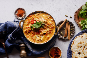 Indian cuisine: chicken tikka masala with rice and naan bread and spices.