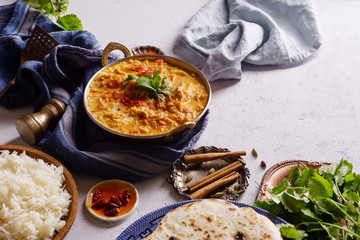 Indian cuisine: chicken tikka masala with rice and naan bread and spices.