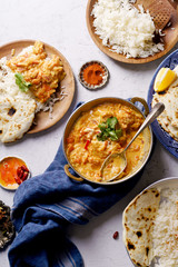 Indian cuisine: chicken tikka masala with rice and naan bread and spices.