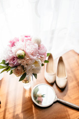 Bride's shoes next to the wedding bouquet.
