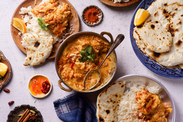 Indian cuisine: chicken tikka masala with rice and naan bread and spices.