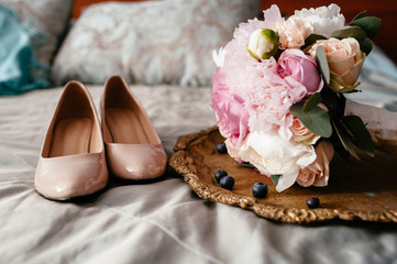 Bride's shoes next to the wedding bouquet.