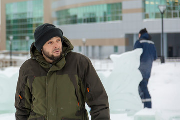 Assembler in overalls on the territory of the ice town