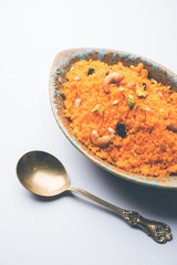 Badaam kesar shira / Sheera or almond saffron halwa, popular Indian dessert served in a bowl. selective focus