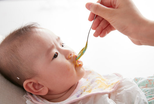 Cute Asian baby being fed