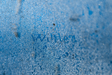 Obraz premium The inscription: winter on a frozen winter window. Background