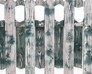 Texture of the wooden fence covered with snow