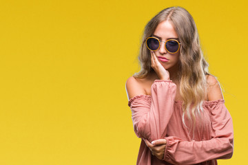 Fototapeta premium Beautiful young blonde woman wearing retro sunglasses over isolated background thinking looking tired and bored with depression problems with crossed arms.