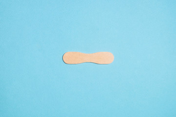 Wooden ice cream stick on cyan background.