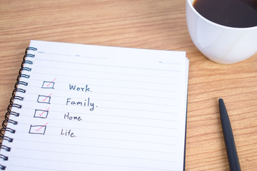 Note book that writes the perfect life goals on a wooden table.
