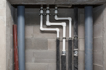 Pipes of heating and water supply system on the background of a concrete wall.