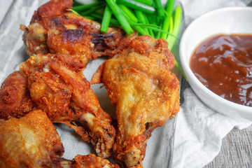 Fried chicken with BBQ sauce on a wooden background.