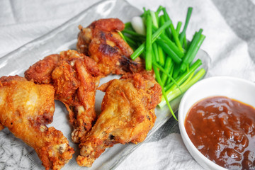 Fried chicken with BBQ sauce on a wooden background.