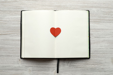 Notebook with heart on wooden background mock up top view. Valentines day. 14 february.