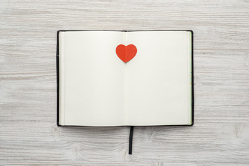 Notebook with heart on wooden background mock up top view. Valentines day. 14 february.
