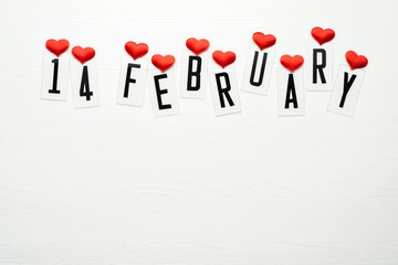 14 February calendar date with red hearts and ribbon band top view. Valentines Day