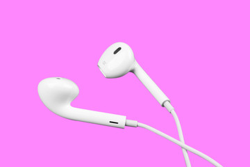 White little headphones isolated on purple background. Earphones isolated on black background.