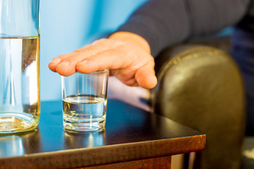 a man refuses to drink a glass of brandy