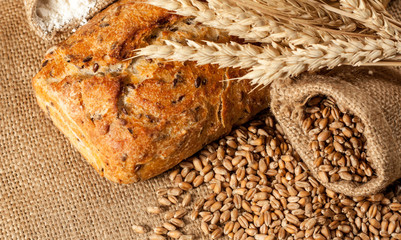 Retro bread in rustic style background.Fresh traditional bread on wooden ground with flour in a sack.