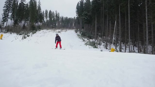 Snowboarder going down from mountain slope. Winter vacation
