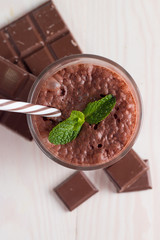 Chocolate, coffee, milk, banana shake on wooden background. Smoothie with mint. Milkshake. Protein diet. Healthy food and drink concept.