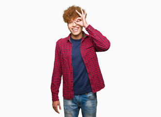 Young handsome student man with afro hair wearing a jacket doing ok gesture with hand smiling, eye looking through fingers with happy face.