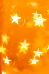 Defocused star lights on golden orange background. Graphic elements to use as backdrops or in greeting cards and other designs.