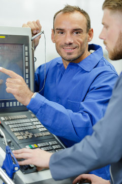 technician pointing to screen of computerised control panel