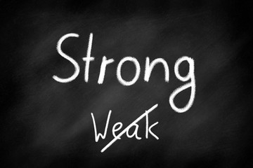 Obraz premium Strong not weak, written on a black chalkboard