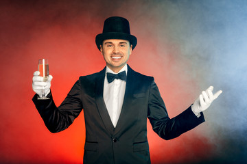 Professional Occupation. Showman in suit hat and gloves standing isolated on wall holding champagne...