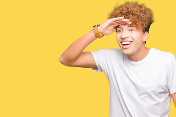 Young handsome man with afro hair wearing casual white t-shirt very happy and smiling looking far...