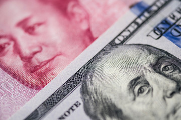 Close up of of China Yuan banknote and US dollar for trade war and economic tax barrier concept.