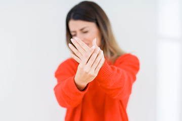 Young woman wearing casual red sweater over isolated background Suffering pain on hands and fingers, arthritis inflammation