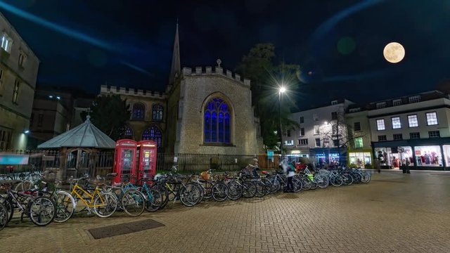 Time lapse view of Cambridge at night with people parking bicycles under a full moon