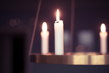 Candles glowing on advent chandelier.