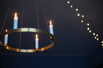 Candles glowing on advent chandelier.