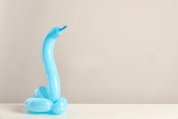 Fototapeta premium Figurka węża wykonana z modelowania balonu na stole na kolorowym tle. Miejsce na tekst