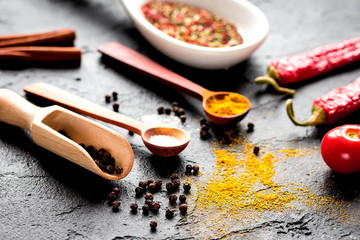 spices in wooden spoon on dark background