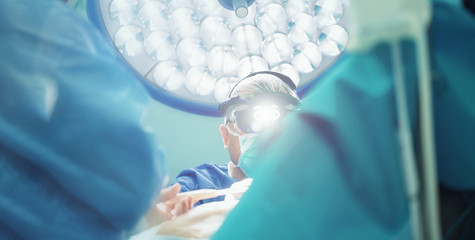 surgeon with lights doing open heart cardiac surgery in hospital cardiovascular microsurgery with...